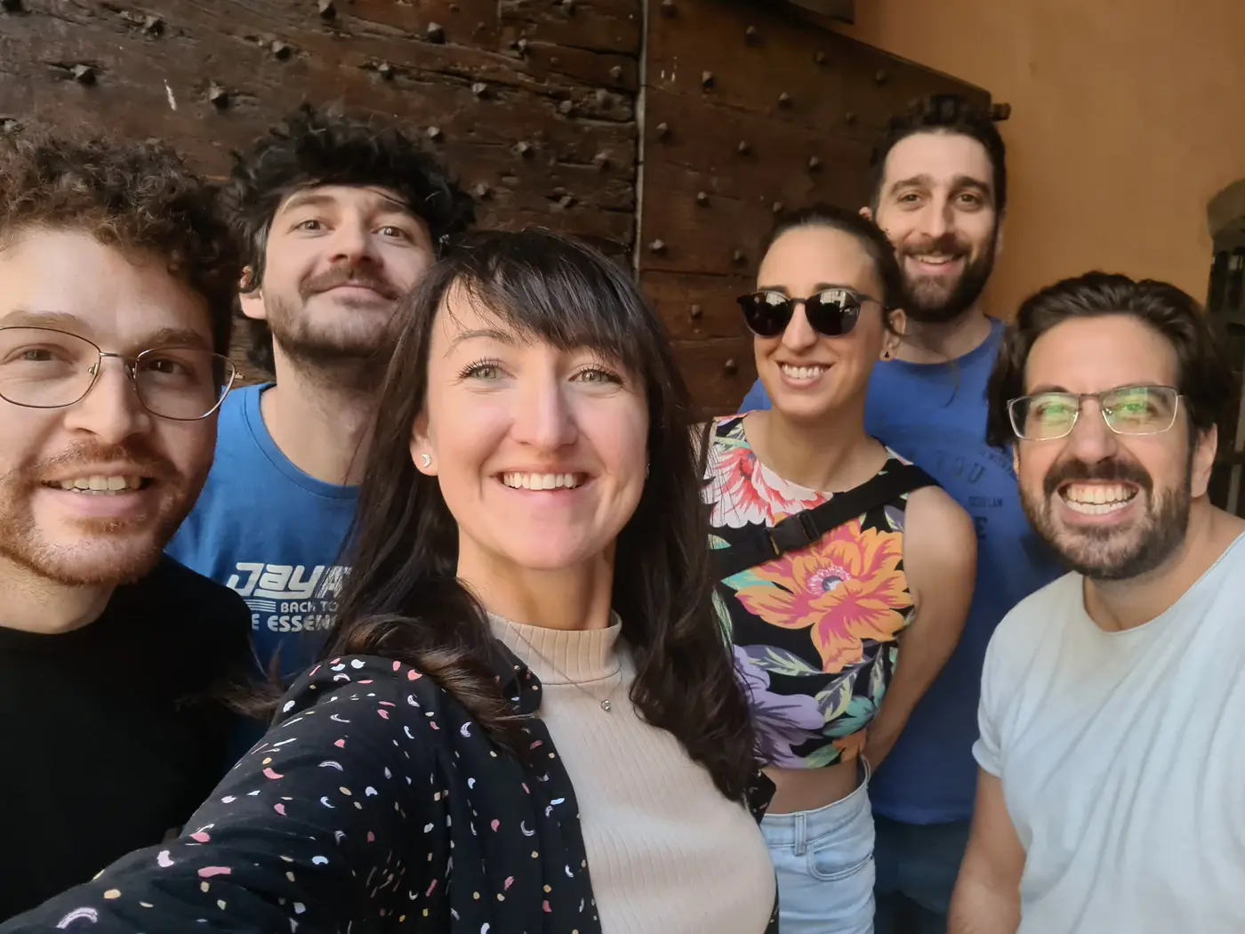 Six Patio members taking a group selfie indoors